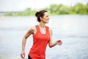 Fit woman jogging by the river.