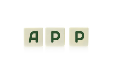 Word "App" on board game square plastic tile pieces, isolated on a white background.