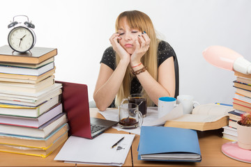 Girl student fell asleep at the table drinking three cups of coffee