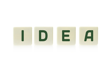 Word "Idea" on board game square plastic tile pieces, isolated on a white background.