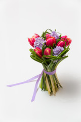 Bouquet of pink tulips and grass on green background