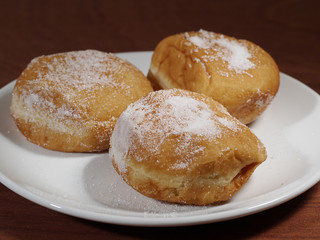 Three donuts on a white plate.