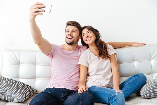 Beautiful young couple is making selfie using a smartphone