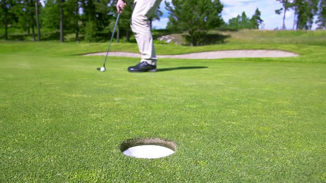 A Golf Ball Putted Towards The Hole Just Missing. Slow Motion