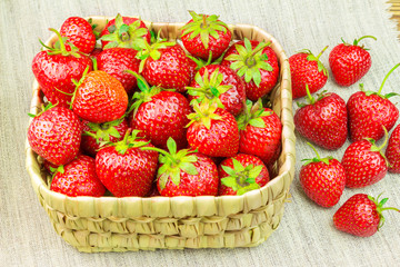 Full basket of ripe, organic strawberries on the canvas.