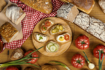 Kanapki zrobione z pełnoziarnistego chleba, jajek, sera, pomidorów, ogórków i szczypiorku - obrazy, fototapety, plakaty