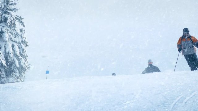 Skiers On Slope With Snow Falling