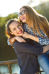 Two playful girls having fun outdoors at sunset light