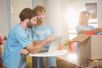 Volunteers using a laptop