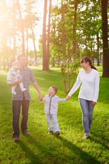 Fototapeta premium happy young family walks in the summer park