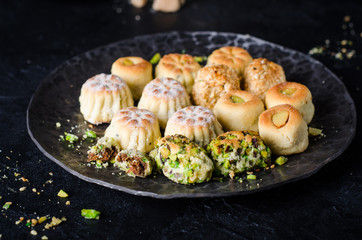 Maamoul or mamoul - arabic cookies stuffed dates or phistachio with icing cugar on dark background. Selective focus