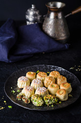 Maamoul or mamoul - arabic cookies stuffed dates or phistachio with icing cugar on dark background. Selective focus