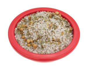 Moroccan blend of spices in a red bowl isolated on a white background.