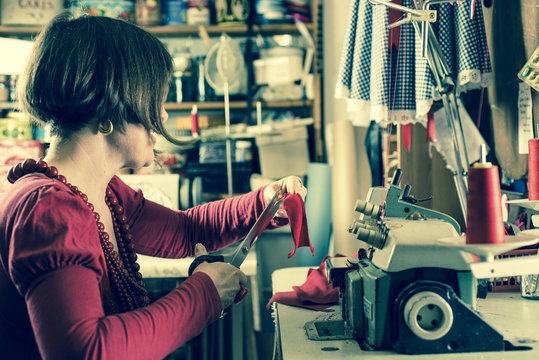 Seamstress Trmming Red Cloth by a Sewing Machine