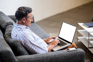 Profile view of businessman working with his laptop
