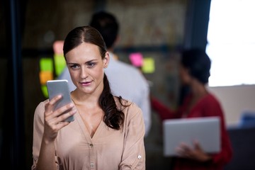 Focus on foreground of woman looking her mobile phone