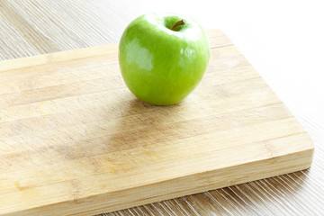 Green apple on cutting board