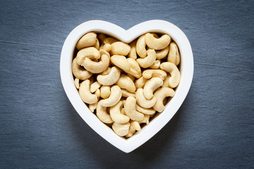 Heart shape bowl filled with raw cashew
