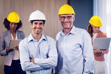 Portrait of two architects standing with arms crossed in office
