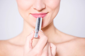 Elegant lady using glossy lipstick