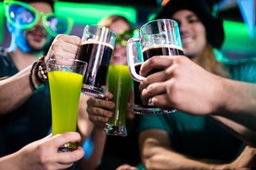 Group of friends toasting beer mugs and drink glasses