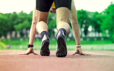 Fototapeta premium Professional male runner taking ready to start position