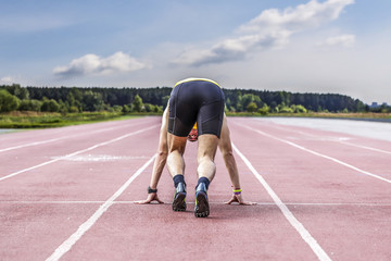 Fototapeta premium Professional male runner taking ready to start position
