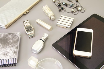 Modern woman's desktop with white smart phone, tablet, dairy and different cosmetics. Flat  lay