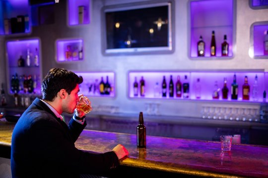 Man drinking alcohol at bar counter