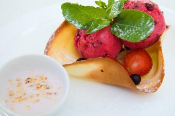 Red ice cream scoops with wafer bowl on white background