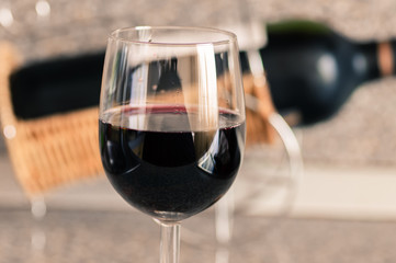 Red wine in a glass bottle on the background