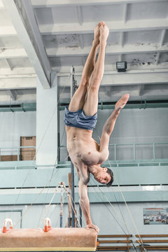 The sportsman during difficult exercise, sports gymnastics