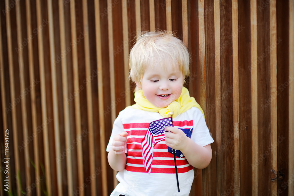 Wall mural Cute toddler boy holding american flag