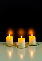 Fototapeta na wymiar closeup to burning candles in darkness