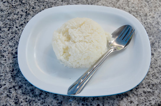 cooked rice on dish with fork and spoon