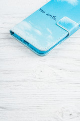 Blue phone case on rustic wooden background and space for text