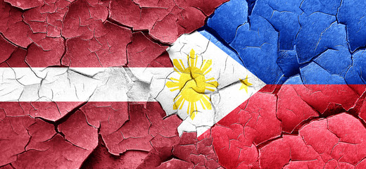 Latvia flag with Philippines flag on a grunge cracked wall