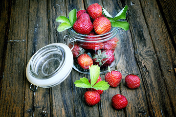 strawberries in a jar on the old wooden background shabby rustic retro style