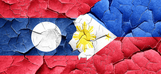 Laos flag with Philippines flag on a grunge cracked wall