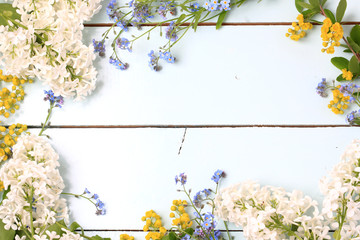 Frame spring flowers blue wooden background flat lay, overhead view