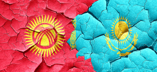 Kyrgyzstan flag with Kazakhstan flag on a grunge cracked wall