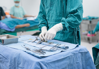 scrub nurse preparing medical instruments for operation