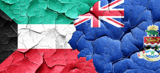 Kuwait flag with Cayman islands flag on a grunge cracked wall
