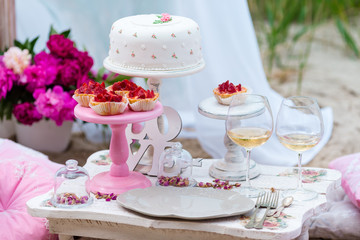 Wedding or party candy bar, decorated dessert table in pink color with cakes. Shabby chic style