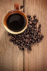 Coffee cup and coffee beans on old wooden