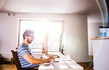 Man sitting at desk working from home on computer