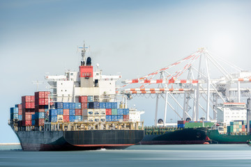 International Transportation Shipping, Container Cargo freight ship with ports crane bridge in harbor, Logistic Import Export background concept, un-mooring of containers cargo ship.