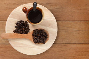 Coffee cup and coffee beans on wood board