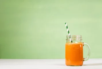 Tuinposter Mason jar with carrot juice smoothie © Tierney
