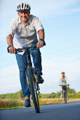 Senioren mit Fahrradhelm fahren Fahrrad